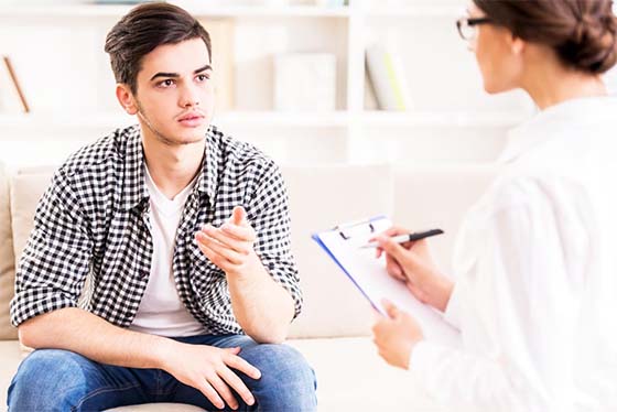 A young man in a session with his therapist during mental health treatment