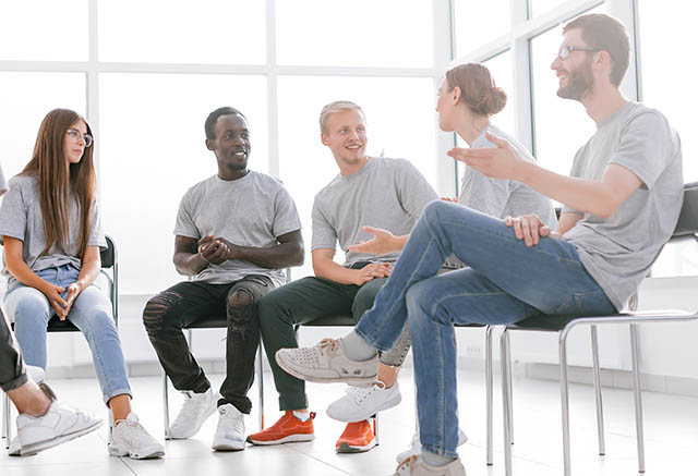 Client's sit in a circle during an outpatient treatment group for addiction rehab.