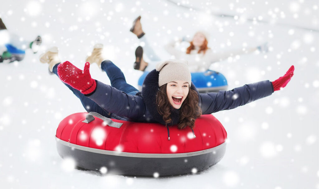 A woman enjoys sober fun during the holidays by inner tubing down a snowy hill.