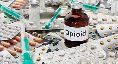 A bottle of opioids on top of many pills, signifying the opiate addiction epidemic.