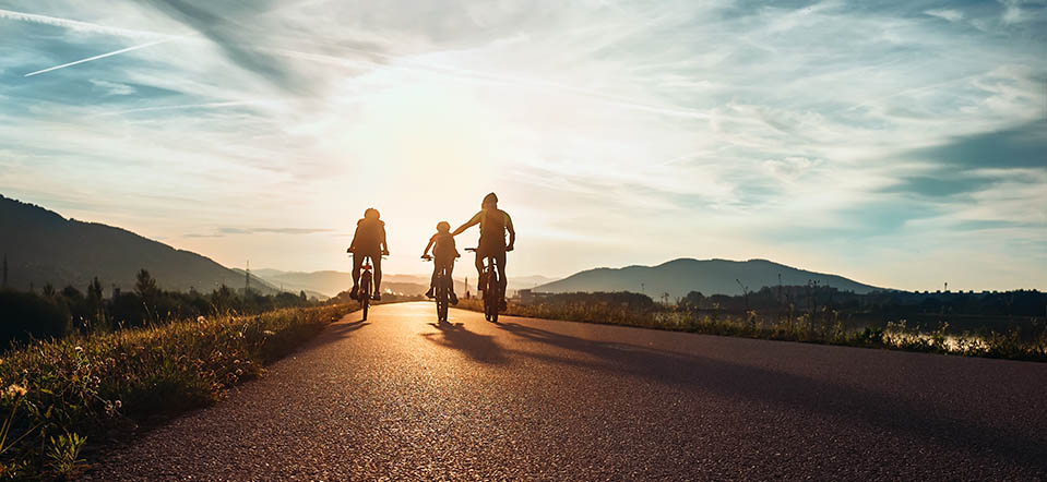 A sober man enjoys a bikeride with his family during sunset, a great way to get in some exercise.