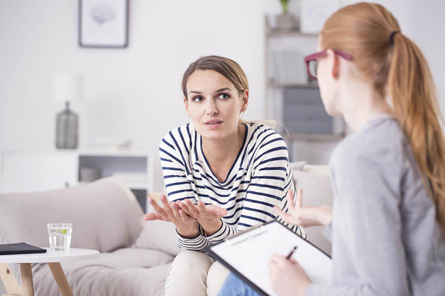 A woman talks to her therapist about happiness during a one-on-one therapy session.