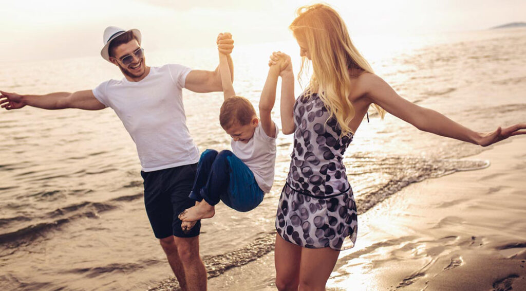 A new mother who is in recovery from drug addiction plays with her child and husband at the beach.