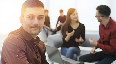 A man sits with others during group therapy while receiving treatment for his PTSD.