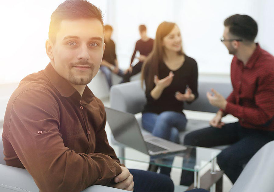 A man sits with others during group therapy while receiving treatment for his PTSD.