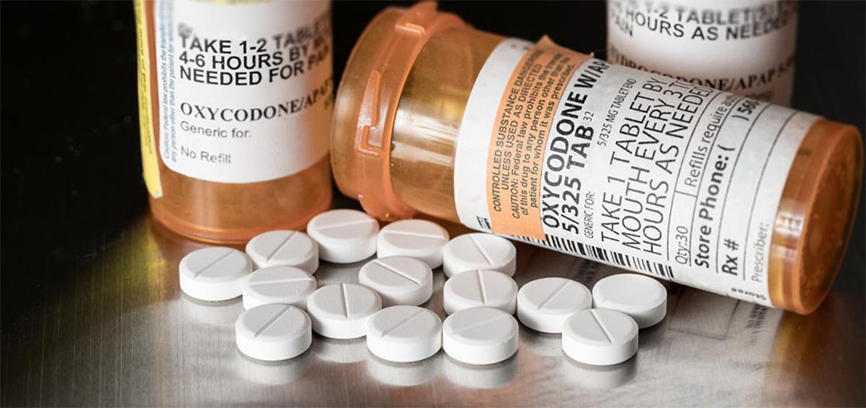 What is oxycodone? Pill bottles of Oxycodone are shown with labels and pills laid out on a table.