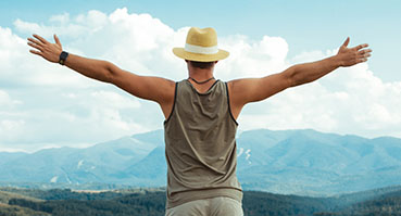 A man stands with his arms up in celebration of his sobriety after stepping down to intensive outpatient treatment.