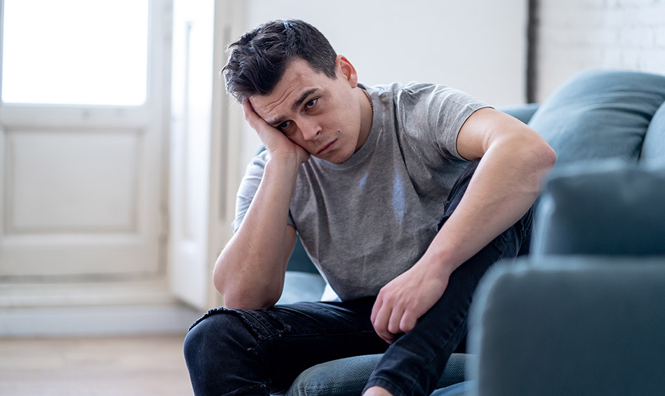 A young man feeling more depressed after a night of drinking, why alcohol makes depression worse.