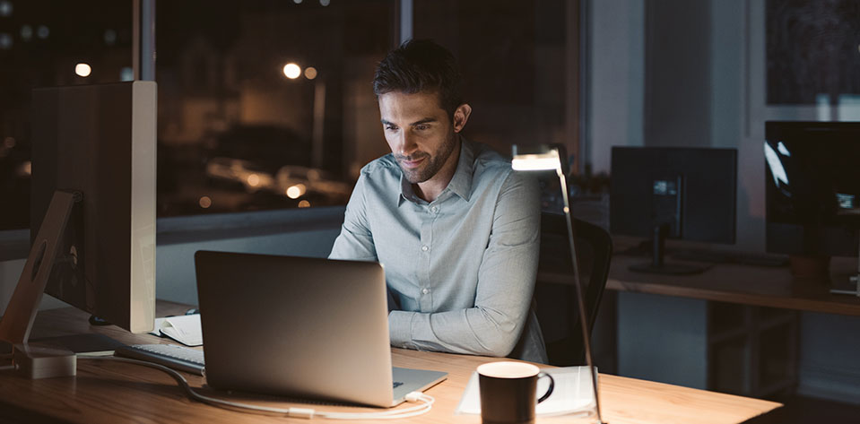 A man works late into the night in his office, channeling his stress into productivity.