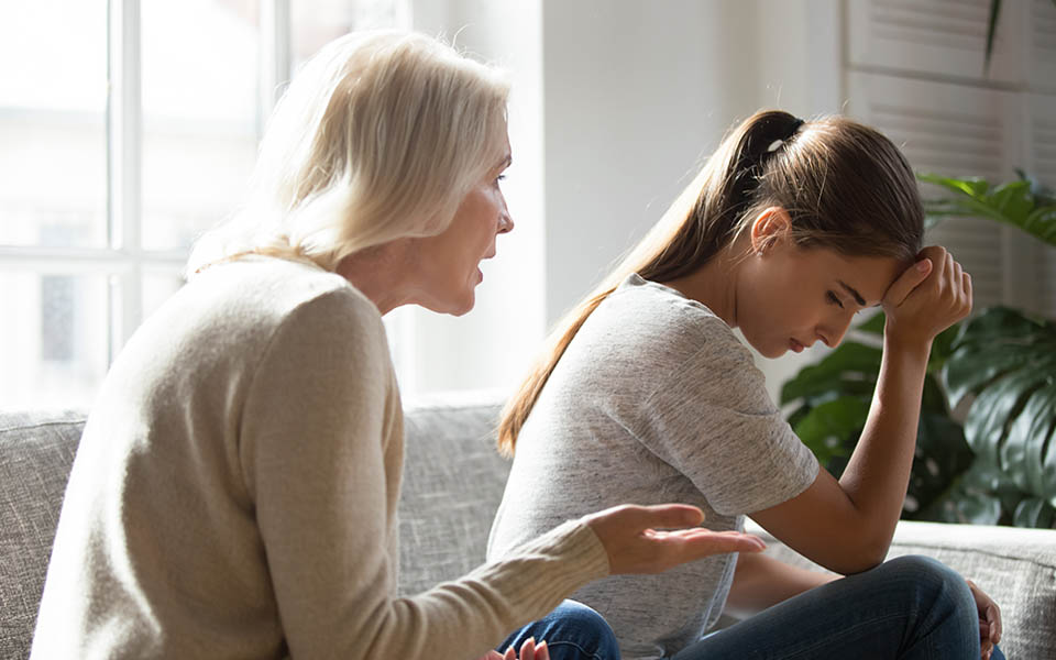 A codependent mother calmly talking to her daughter and setting healthy boundaries.