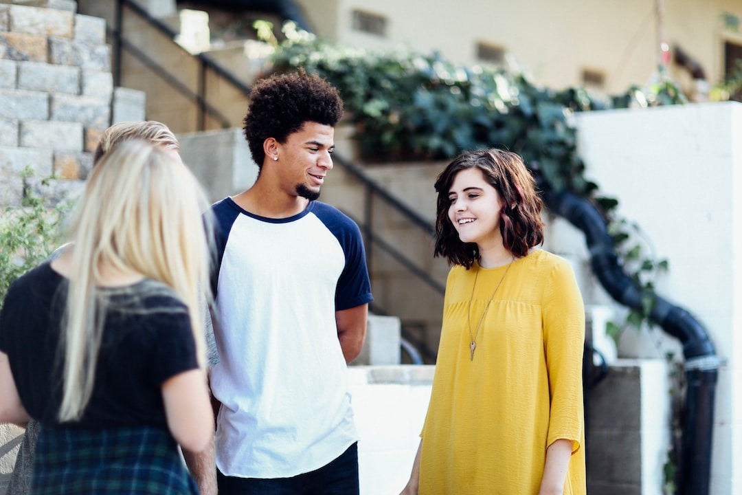 Young adults stand outside their outpatient treatment program chatting with eachother.