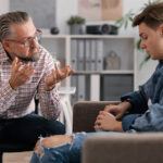 A client sits with a therapist utilizing DBT Therapy for treating his addiction and mental health.