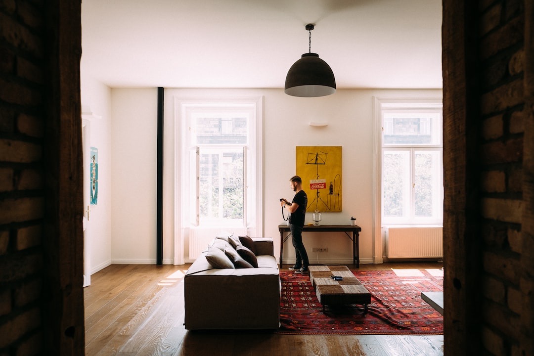 Person standing in a bright, modern living room alone, symbolizing the challenges and possibilities of achieving sobriety at home