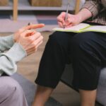 close up of a patients hands and a therapists notes during a therapy session at 12 South Recovery
