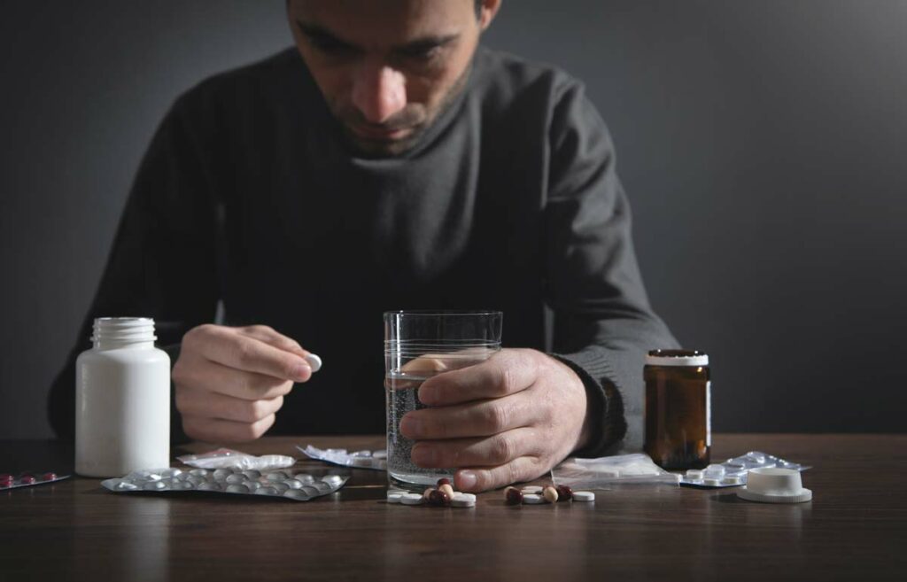 Caucasian depressed man with a pills.