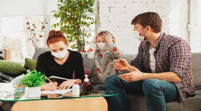 Family sitting in a living room with a face mask stressed