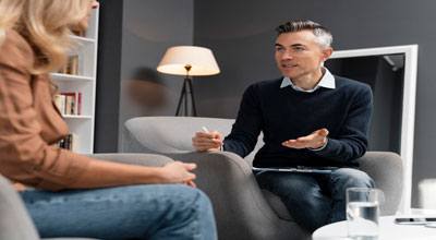 Woman sitting at individual therapy listening to their therapist