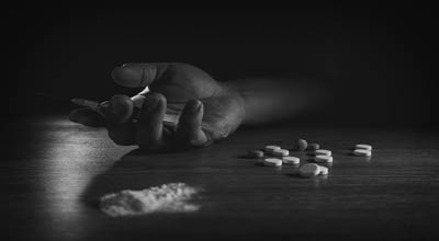 Hand hold laying on the table next to drugs