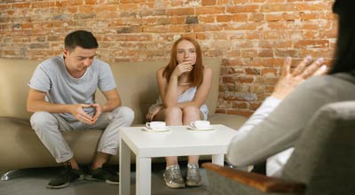 A couple sitting with a therapist determining if they have addictive traits