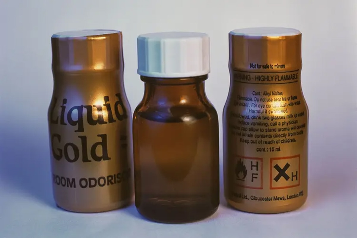 Various bottles of poppers, including “Liquid Gold,” commonly used as inhalants for recreational purposes, shown with warning labels highlighting flammability and health risks.