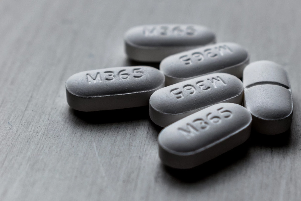 Close-up of white M365 pills on a table, representing the risks of prescription painkiller misuse and opioid addiction awareness at 12 South Recovery in Orange County, CA.