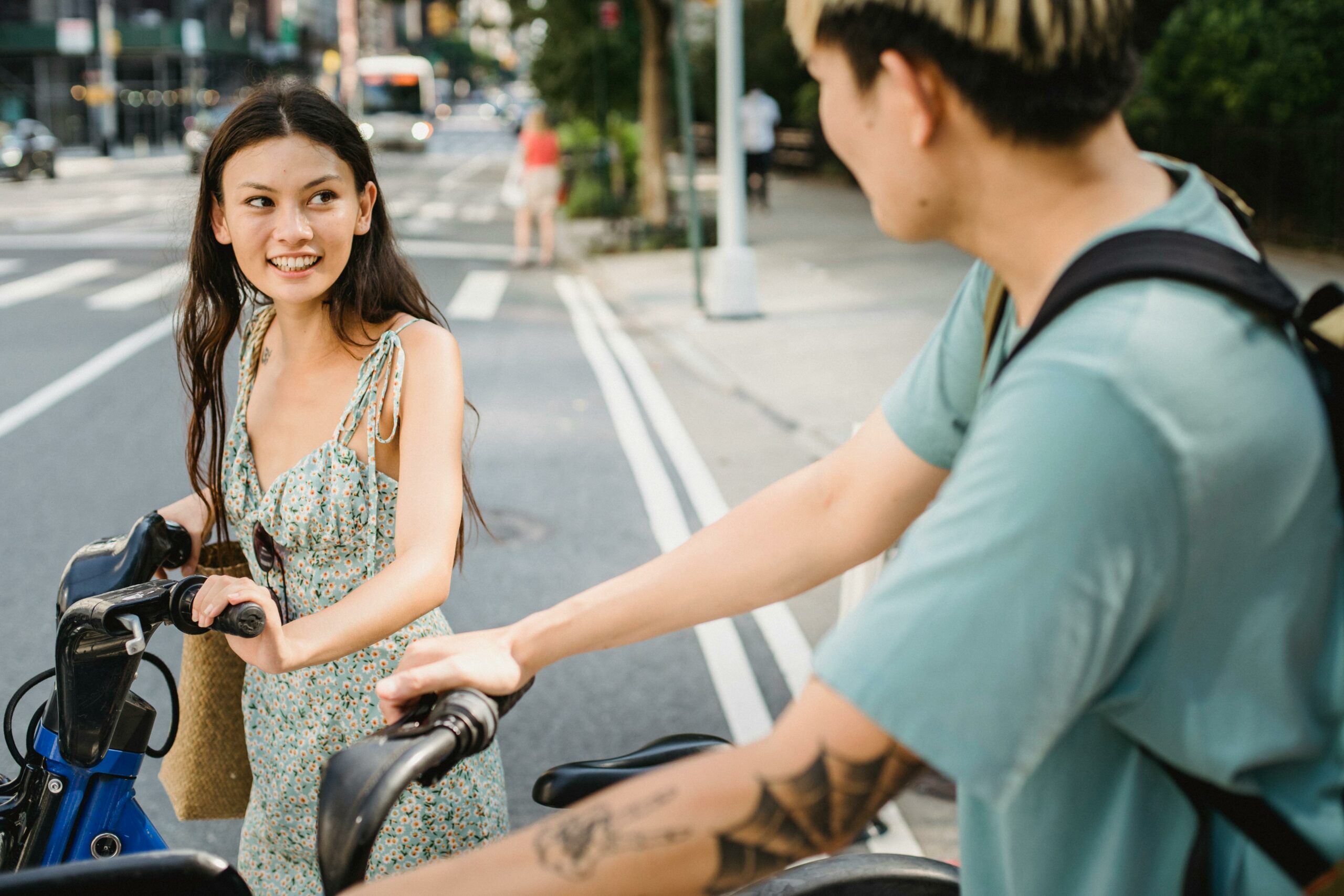 Two young adults with bicycles talking outdoors in a calm setting, representing healing and connection during Orange County residential treatment and detox recovery.