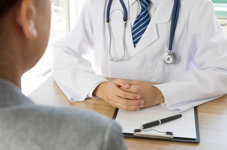 Doctor consulting with a patient during a medical evaluation, representing medical supervision in Orange County residential treatment and detox programs.